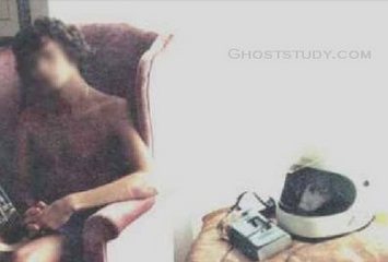 Uploaded on a paranormal forum, the caption of the photograph goes as:This is cropped from a larger photo. The guy in the chair was recovering from a motorcycle accident (his face has been blurred to protect his identity). When the photo was developed, a face was seen peering out of the helmet on the table. Although the photo is in color, the face is black &amp; white; pretty much how a real person&rsquo;s face would reflect back from the darkly tinted glass. If it had a strong light on it - like the sun coming through.. except no one was there to reflect.