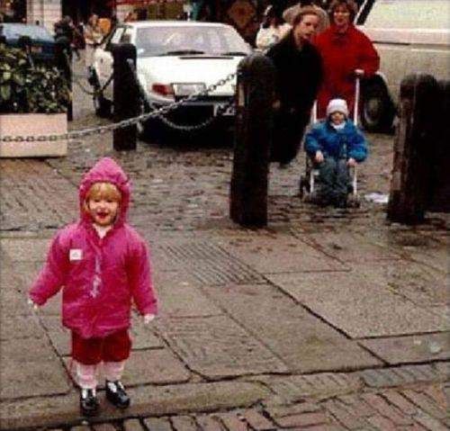 An eerie picture where the woman in the back, dressed in all black appears to be floating. 
