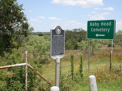 Baby Head Cemetery is a cemetery located on Highway 16, approximately 9 miles north of the city of Llano, Texas. The sign reads as follows:According to local oral tradition, the name Babyhead was given to the mountain in this area in the 1850s when a small child was killed by Indians, and its remains left on the mountain. A local creek also carried the name, and a pioneer community founded in the 1870s became known as Baby Head. The oldest documented grave here is that of another child, Jodie May McKneely, who died on New Year&rsquo;s Day 1884. The cemetery is the last physical reminder of the Baby Head community, which once had numerous farms, homes and businesses