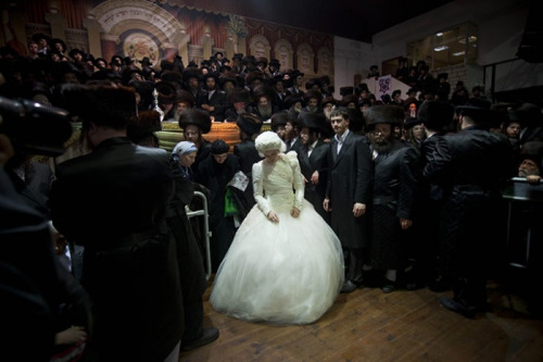 Petah Tikva, Israel: An orthodox Jewish bride enters the men&rsquo;s section in a wedding hall during her traditional Jewish wedding, to fulfill the mitzvah tantz, in which family members and honoured rabbis are invited to dance in front of the bride. Photo Credit: Oded Balilty