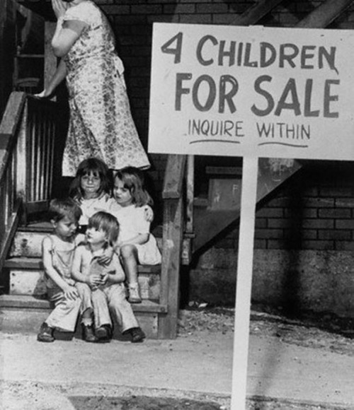 A penniless mother hides her face in shame after putting her children up for sale. Chicago, 1948.